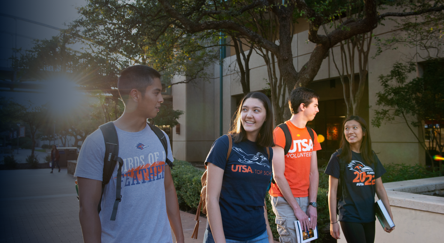Group of four students walking and talking